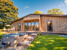 An outdoor area with a hot tub and seating at Sycamore Lodge Nantmel near Rhayader