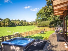 An outdoor space with a hot tub and seating area at Sycamore Lodge Nantmel near Rhayader
