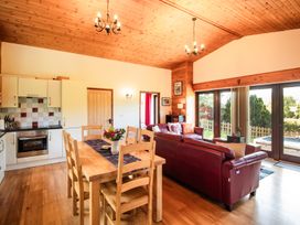 A living room with a dining area and kitchen at Sycamore Lodge Nantmel near Rhayader