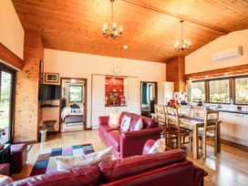 A living room with a sofa and dining area at Sycamore Lodge Nantmel near Rhayader