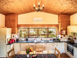 A kitchen with a table and chairs at Sycamore Lodge Nantmel near Rhayader