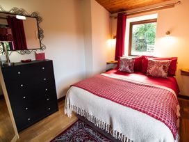 A bedroom with a bed and a dresser at Sycamore Lodge Nantmel near Rhayader