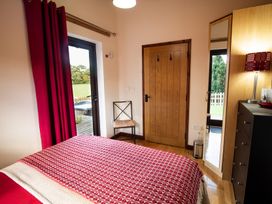 A bedroom with a bed and curtains at Sycamore Lodge Nantmel near Rhayader