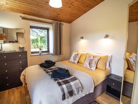 A bedroom with a bed and window at Sycamore Lodge Nantmel near Rhayader