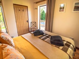 A bedroom with a bed and towels arranged at Sycamore Lodge Nantmel near Rhayader