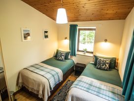 A bedroom with two single beds and a window at Sycamore Lodge Nantmel near Rhayader