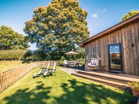 An outdoor area with seating and a tree at Sycamore Lodge Nantmel near Rhayader