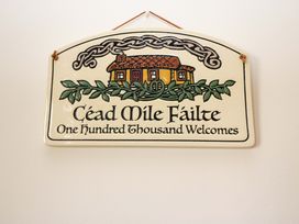 A sign with a house illustration and text reading Céad Míle Fáilte at No. 4 Lansdowne Village, Kenmare, The Ring of Kerry, County Kerry