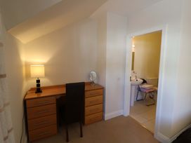 A bedroom with a desk and a door leading to a bathroom at No. 4 Lansdowne Village, Kenmare, The Ring of Kerry, County Kerry