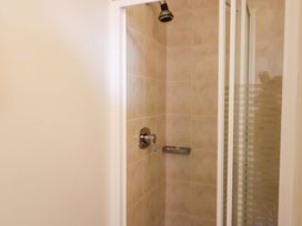 A shower with a glass door and tiled walls at No. 4 Lansdowne Village, Kenmare, The Ring of Kerry, County Kerry