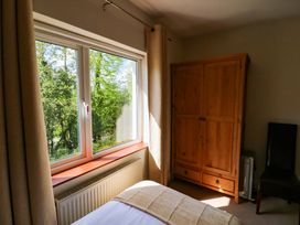 A bedroom with a window, wardrobe and chair at No. 4 Lansdowne Village, Kenmare, The Ring of Kerry, County Kerry