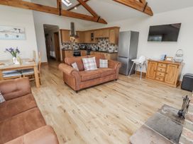 A living room with a sofa and dining table at Grey Croft Embleton