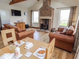 A living room with a sofa and a fireplace at Grey Croft in Embleton