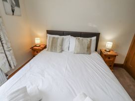 A bedroom with a bed and nightstands at Grey Croft in Embleton