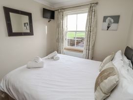 A bedroom with a bed and decorative items at Grey Croft in Embleton