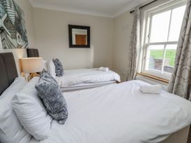 A bedroom with two beds and a window at Grey Croft in Embleton