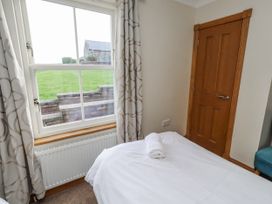 A bedroom with a bed and window at Grey Croft in Embleton