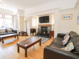 A living room with a television and fireplace at Meadway House in Rhos-on-Sea