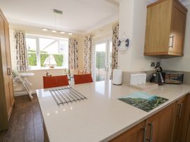 A kitchen with countertop, cabinets, kettle, toaster, and window at Meadway House Rhos-on-Sea