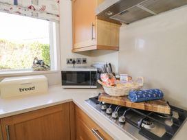 A kitchen with a microwave and bread box at Meadway House Rhos-on-Sea