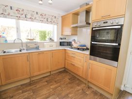 A kitchen with various appliances and cabinets at Meadway House Rhos-on-Sea