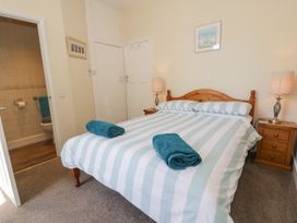 A bedroom with a bed and bathroom access at Meadway House in Rhos-on-Sea
