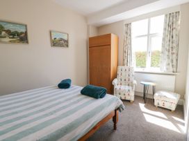 A bedroom with a bed and chairs at Meadway House in Rhos-on-Sea