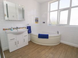 A bathroom with a bathtub and sink at Meadway House in Rhos-on-Sea