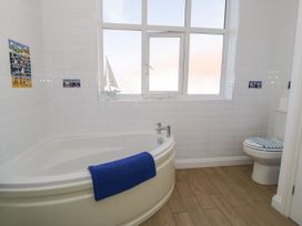 A bathroom with a bathtub and toilet at Meadway House in Rhos-on-Sea