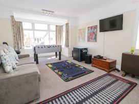 A snug room with a foosball table and a television at Meadway House in Rhos-on-Sea