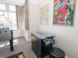 A game room with a foosball table and arcade cabinet at Meadway House Rhos-on-Sea