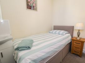 A bedroom with a bed and a sink at Meadway House in Rhos-on-Sea