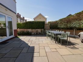 A garden with a table and chairs on a patio at Meadway House in Rhos-on-Sea