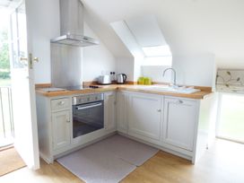A kitchen with an oven stovetop toaster kettle sink and cabinets at The Stables Crayke Lodge in Easingwold