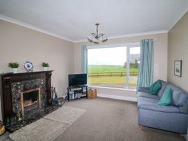 A living room with a fireplace and sofa at Findale, Carne near Rosslare, County Wexford