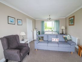 A living room with an armchair and a grey sofa at Findale Carne near Rosslare, County Wexford