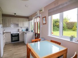 A kitchen with a table and chairs at Findale in Carne near Rosslare, County Wexford