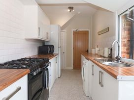 A kitchen with a gas stove, microwave, and sink at Sea View House in Hornsea