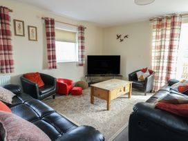 A living room with sofa and coffee table at Ty Ni Caeathro near Caernarfon