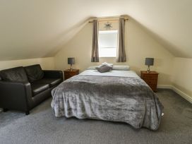 A bedroom with a bed and a sofa at Ty Ni in Caeathro near Caernarfon