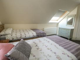 A bedroom with two beds and a dresser at Ty Ni in Caeathro near Caernarfon