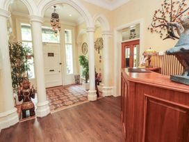 A hallway with a reception desk and decorative elements at Eden Lodge in Bardsea
