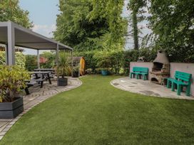 A garden with a patio and seating area at Eden Lodge in Bardsea