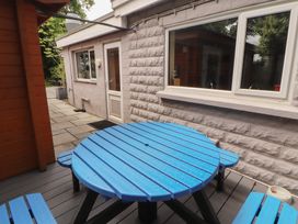 An outdoor area with a blue circular table and a stone pathway at Eden Lodge in Bardsea