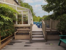 A garden with decking, benches, and steps at Eden Lodge in Bardsea