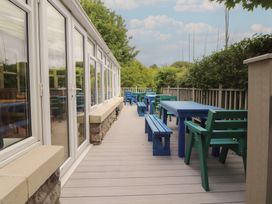 An outdoor dining area with blue tables and benches at Eden Lodge in Bardsea