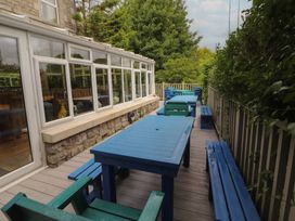 An outdoor seating area with tables and benches at Eden Lodge in Bardsea