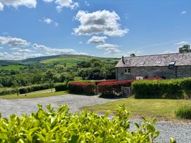 A house with a gravel driveway and greenery at Ysgubor - The Barn in Boncath near Crymych