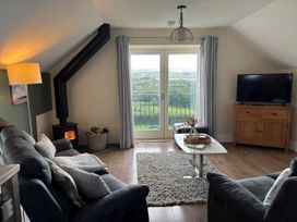 A living room with a stove and television at Ysgubor - The Barn Boncath near Crymych
