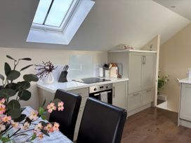 A kitchen with a stove and cabinetry at Ysgubor - The Barn in Boncath near Crymych